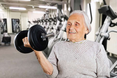 Strong Retired Grandmother Women Lifting Weight While Exercising
