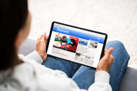 Watching News On Tablet Computer Screen Online At Homeの写真素材