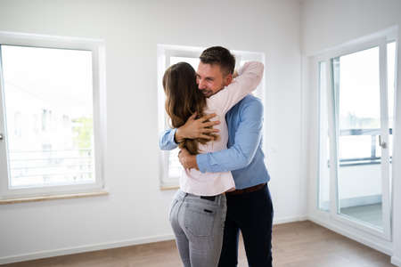 Excited Family Couple Hugging In New Houseの写真素材