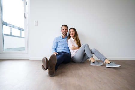 Young Happy Couple Thinking And Dreaming In New Houseの写真素材