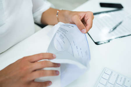 Paycheck In Open Envelope. Holding Payroll Chequeの写真素材