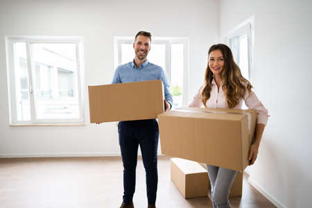 Family Relocation Carrying Boxes Into New Home