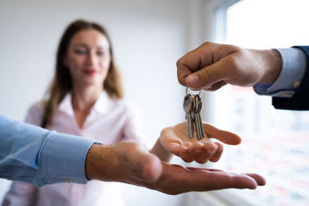 Agent Giving Home Keys To Couple. Closing Sale