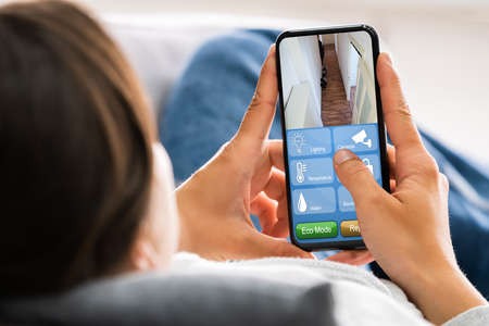 Holding Mobile Phone Using Smart Home Security And Automation