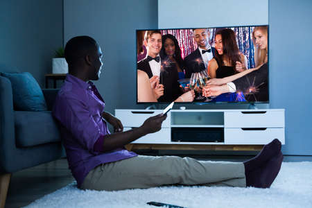 Large Version Of African Man Watching TV Movie Or Television