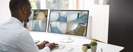 Security Guard Looking At CCTV Surveillance Video Footage