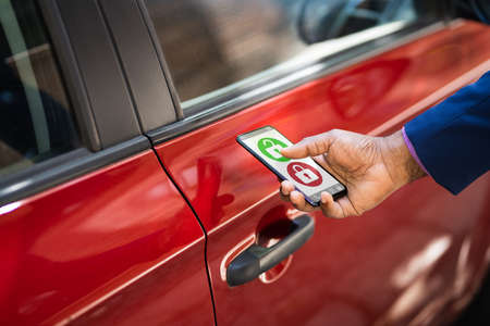 African Man Unlocking Car Using Smartphone App