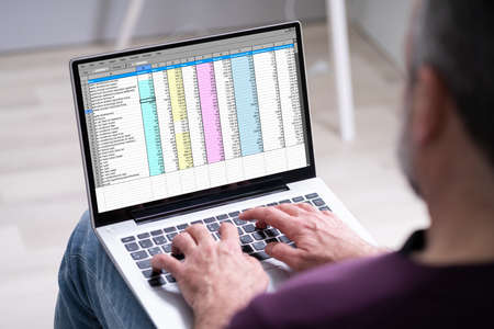 Elder Man Using Spreadsheet Data On Laptop Computerの写真素材