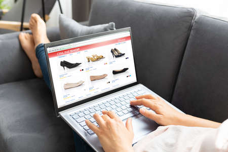 Woman Online Ecommerce Shopping Using Laptop On Sofaの写真素材