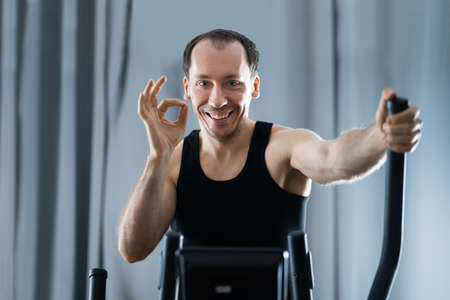 Man Training On Elliptical Trainer At Homeの写真素材