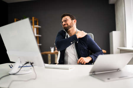 Young Man With Tense Shoulder Pain. Office Posture Problem