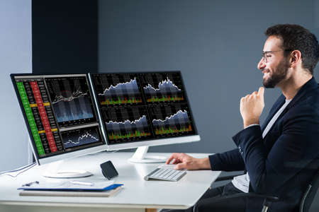 Stock Exchange Business Analyst Using Computer With Multiple Screen