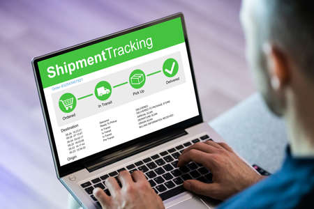Man Checking Courier Service On Laptop Computerの写真素材