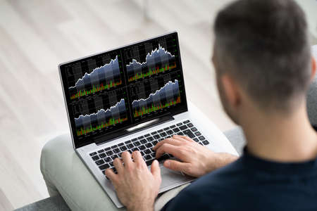 Stock Broker Trading Stocks Online On Laptopの写真素材