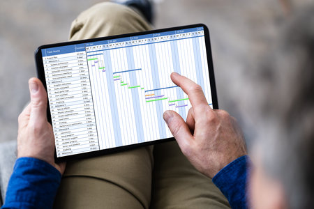 Man Using Gantt Chart Schedule Software On Computer