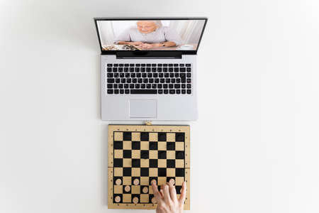 Woman Playing Checkers Online Using Video Conference Call