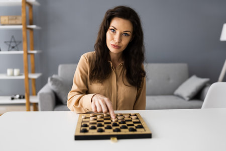 Woman Playing Checkers Online Using Video Conference Call