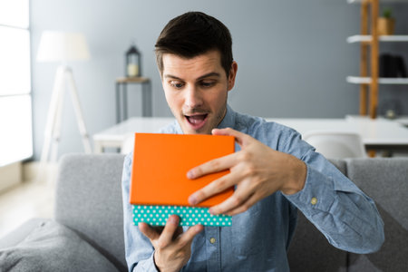 Happy Man Sitting At Home Opening Gift