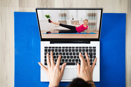 Watching Online Yoga Video Program Exercise On Laptop Computer At Homeの写真素材