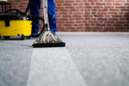 Janitor Cleaning Carpet With Vacuum Cleaner At Homeの写真素材