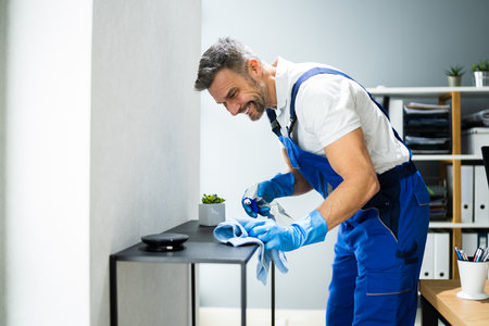 Professional Janitor Office Cleaning Service. Man With Chemical Sprayの写真素材