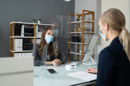 Insurance Consultant Or Lawyer In Bank With Sneeze Guard And Maskの写真素材