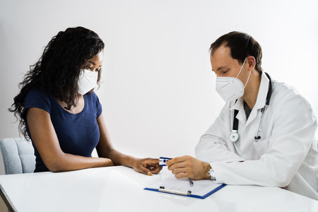 African American Patient At Hospital Meeting Doctor In Face Maskの写真素材