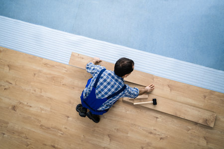 Hardwood Floor Renovation. Construction Worker Doing New Laminate Installationの写真素材