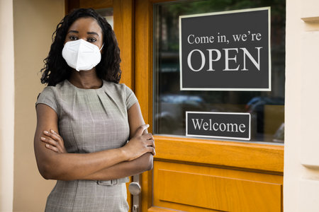 Business Owner At Store Entrance Holding Open Signの写真素材