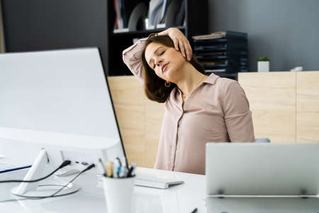 Woman Stretching At Office Desk. Worker Stretch Workoutの写真素材