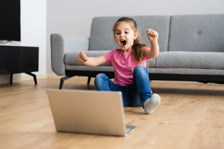 Excited Child Browsing Internet On Laptop Computerの写真素材