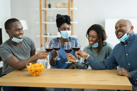 African American Having Wine Party Wearing Maskの写真素材