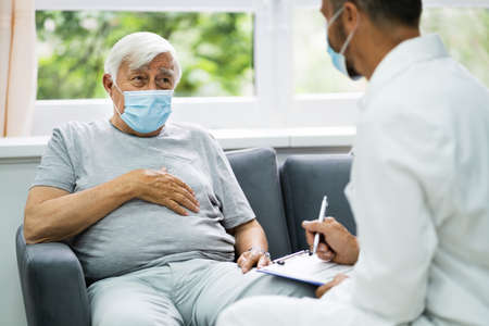 Doctor Talking To Elderly Patient At Home