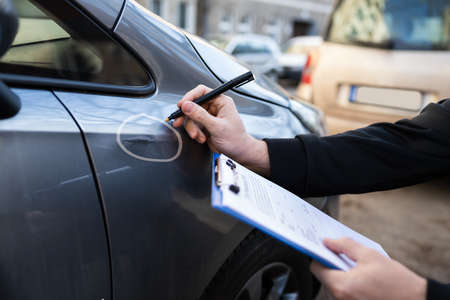 Insurance Agent Or Adjuster Inspecting Car After Accidentの写真素材
