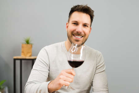 Man Drinking Wine Alcohol In House Roomの写真素材