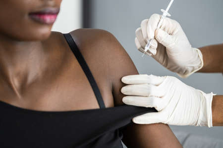 African American Nurse Making Vaccine Injection In Armの写真素材