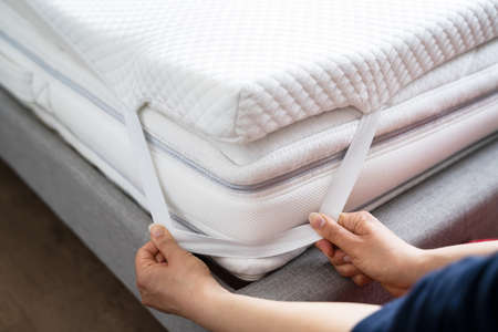 Mattress Topper Being Laid On Top Of The Bedの写真素材