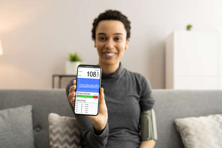 Blood Pressure Check Using Smart Monitor. African Patient Woman