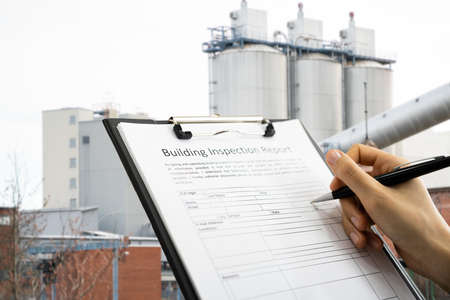 African American Inspector Checking Building Inspection Report