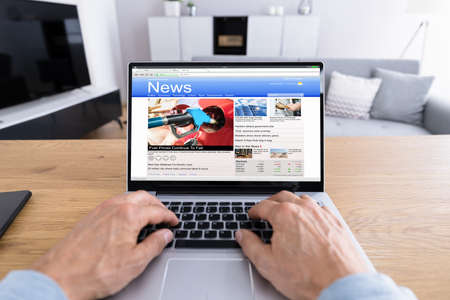 Man Reading News Website On Computer Screen