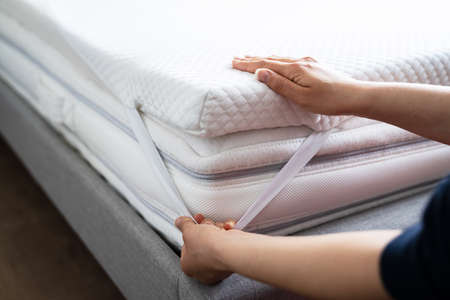 Mattress Topper Being Laid On Top Of The Bed