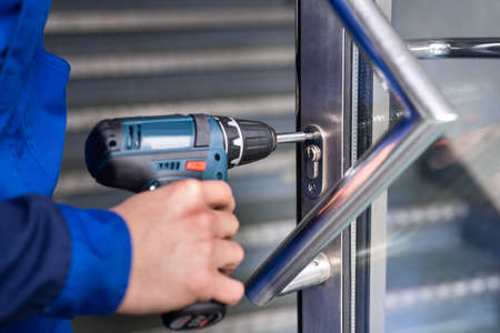Locksmith Man Repairing And Changing Metal Door Lockの写真素材