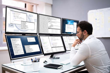 Software Developer Programming On Computer Monitor Screens