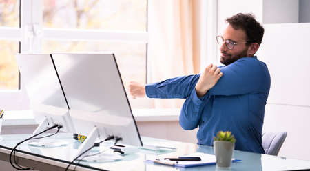 Stretching Exercise At Office Desk In Chair