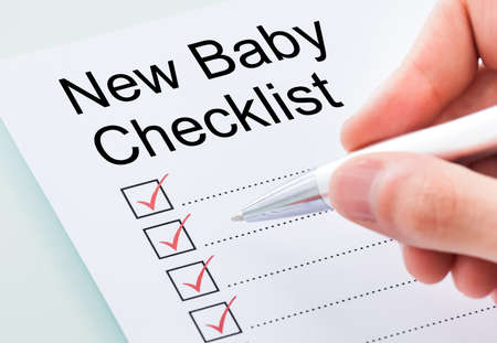 New Baby Planning Checklist. Hand Filling Check Listの写真素材