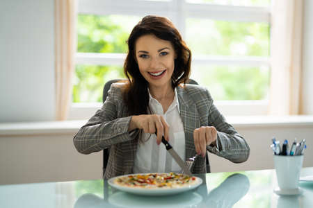 Eating Virtual Lunch. Business Woman Tasting Foodの写真素材