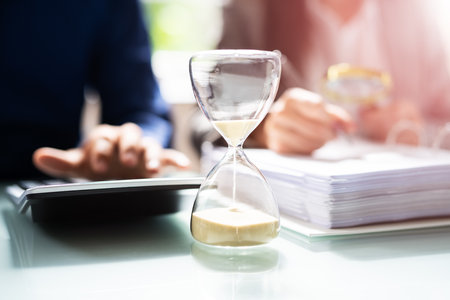 Hourglass And Time Crunch With Document In Office