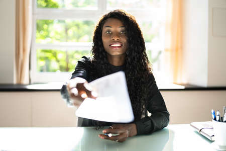 African Business Woman Giving Paycheck Or Payroll Chequeの写真素材