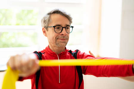 Elderly Man Stretching Rehab Physio Band With Physiotherapist