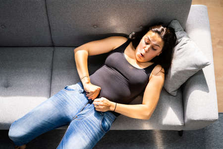 Woman Struggling With Tight Jeans. Weight Gainの写真素材